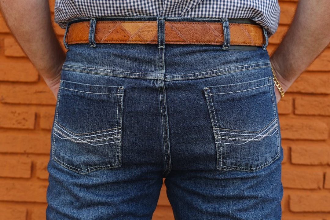 Calça masculina Strut bootcut tradicional em jeans stone, modelagem para usar por fora do cano da bota