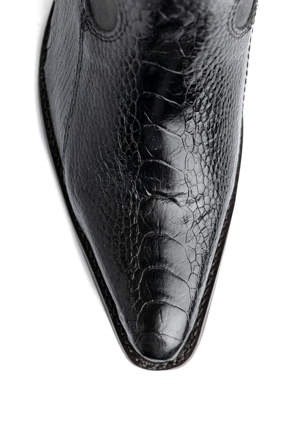 Detalhe do bico fino da bota feminina Strut em couro de canela de avestruz preta