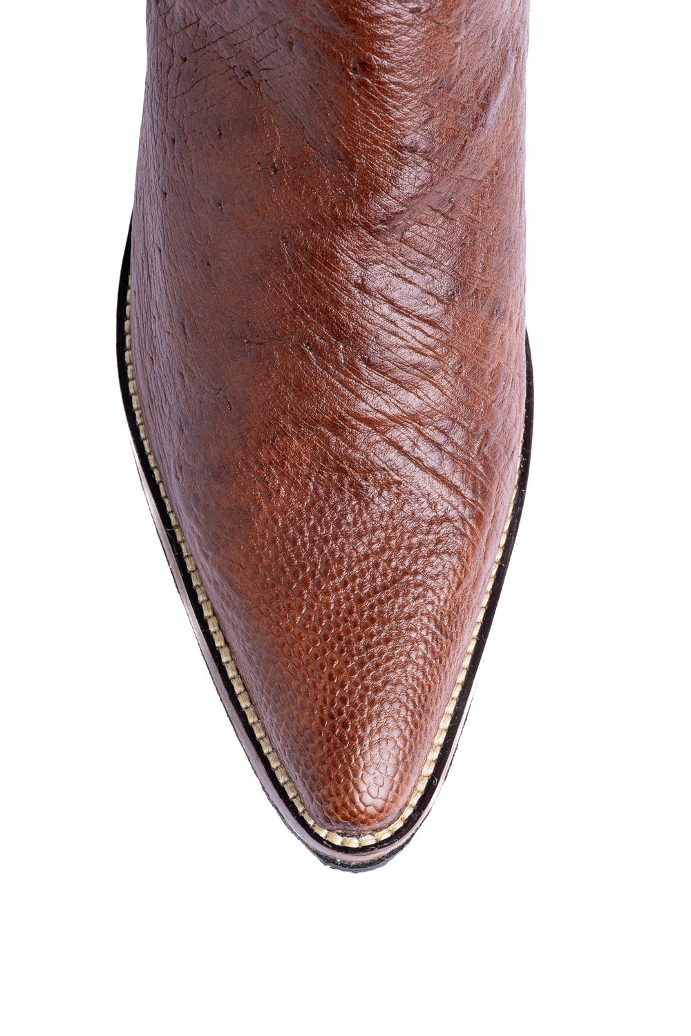 Detalhe do bico fino da bota masculina Strut em couro de avestruz liso caramelo