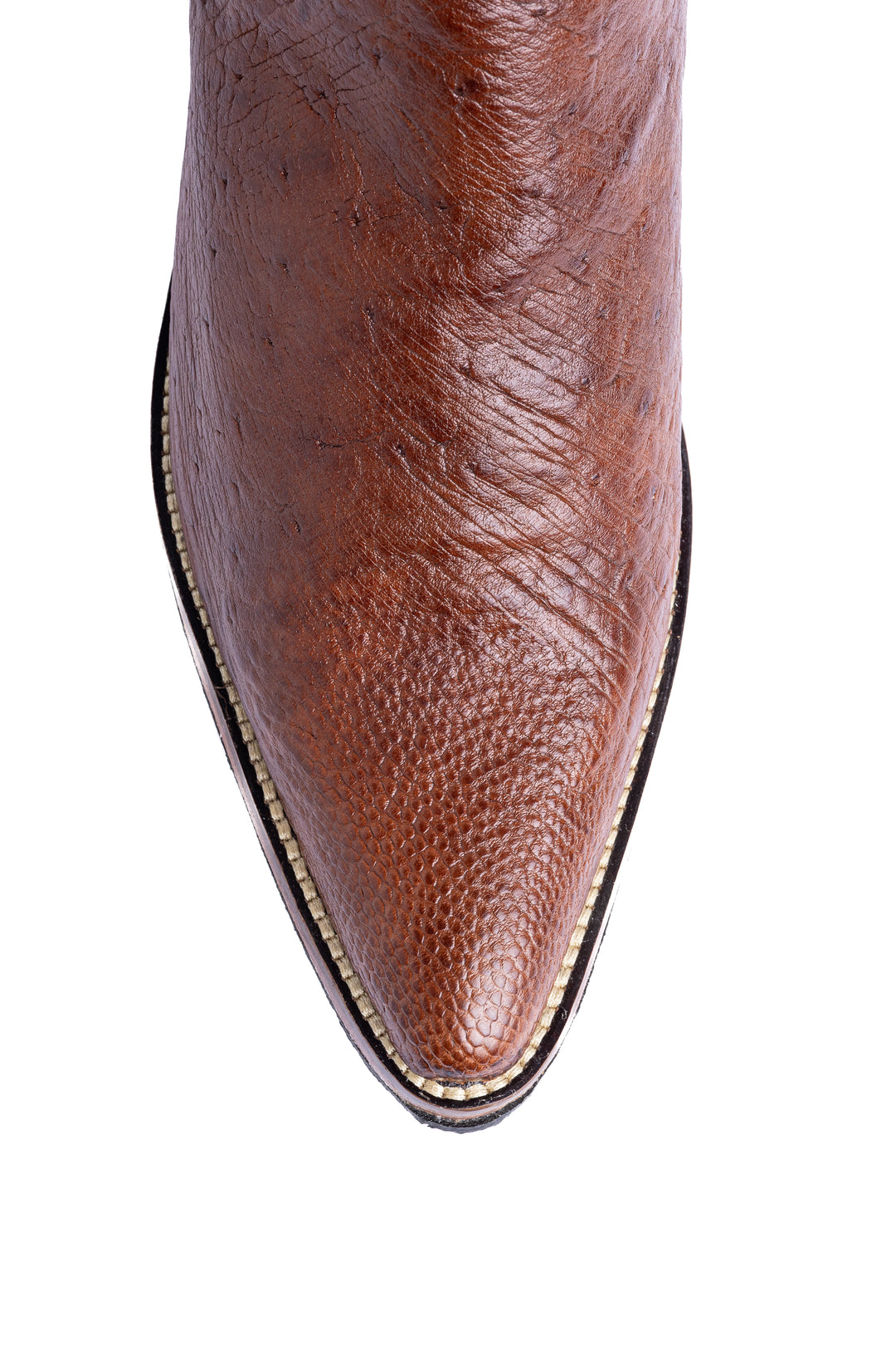 Detalhe do bico fino da bota masculina Strut em couro de avestruz liso caramelo