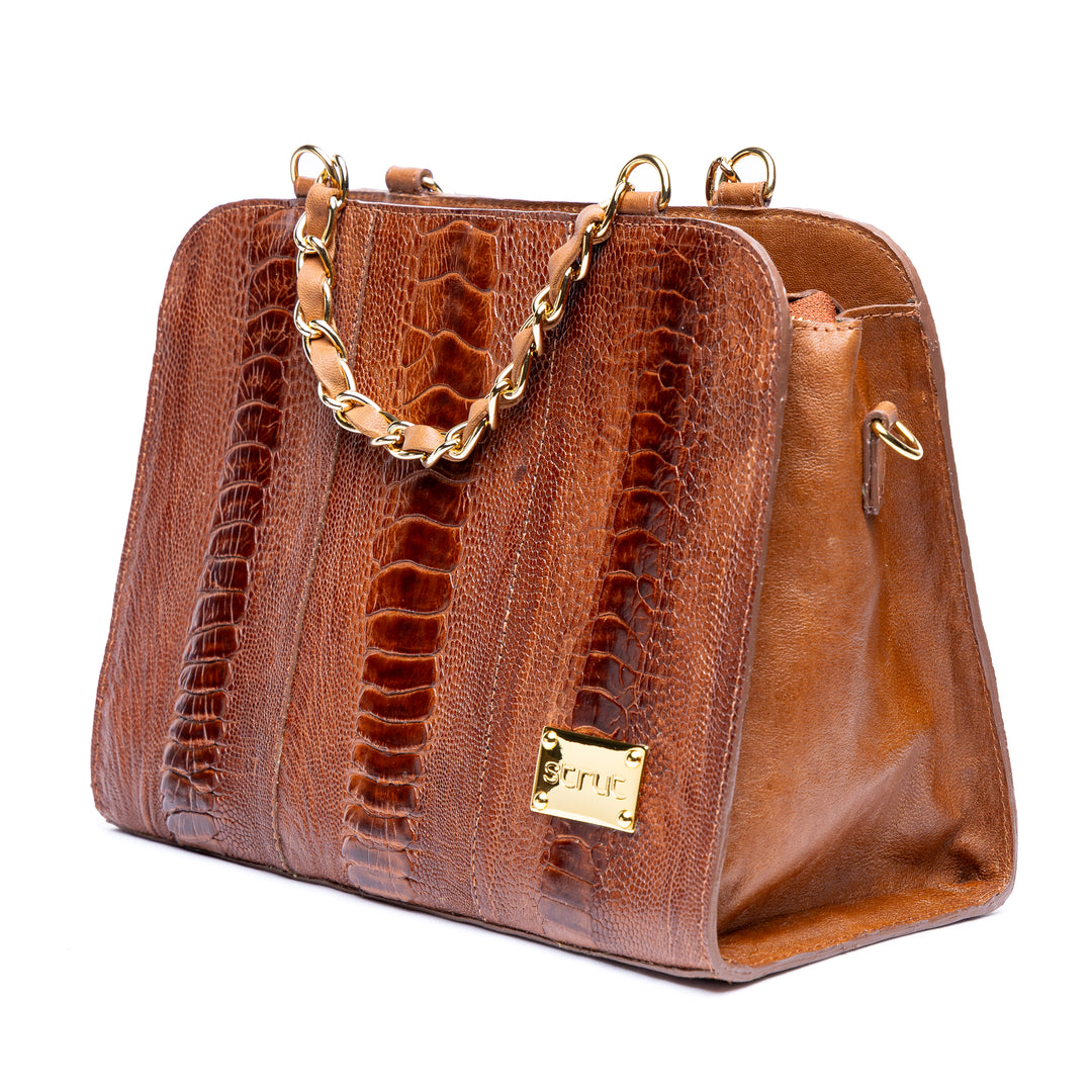 Perfil da bolsa social Strut mostrando laterais em couro liso e estrutura firme