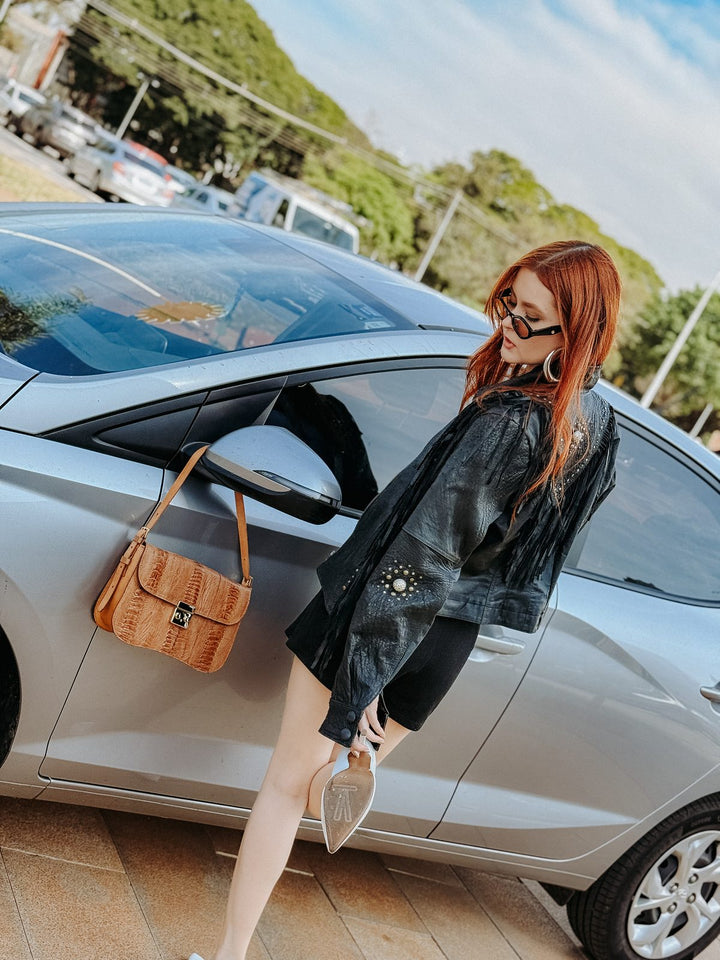 Bolsa baguete Strut em canela de avestruz caramelo usada a tiracolo em look urbano