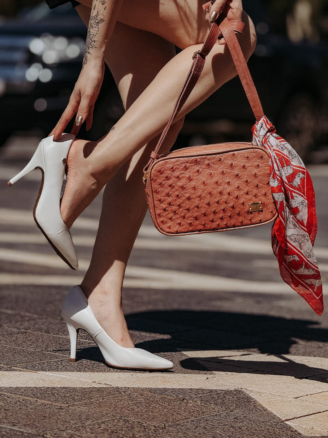 Bolsa camera bag Strut em couro de avestruz cheio caramelo com lenço vermelho e scarpin branco