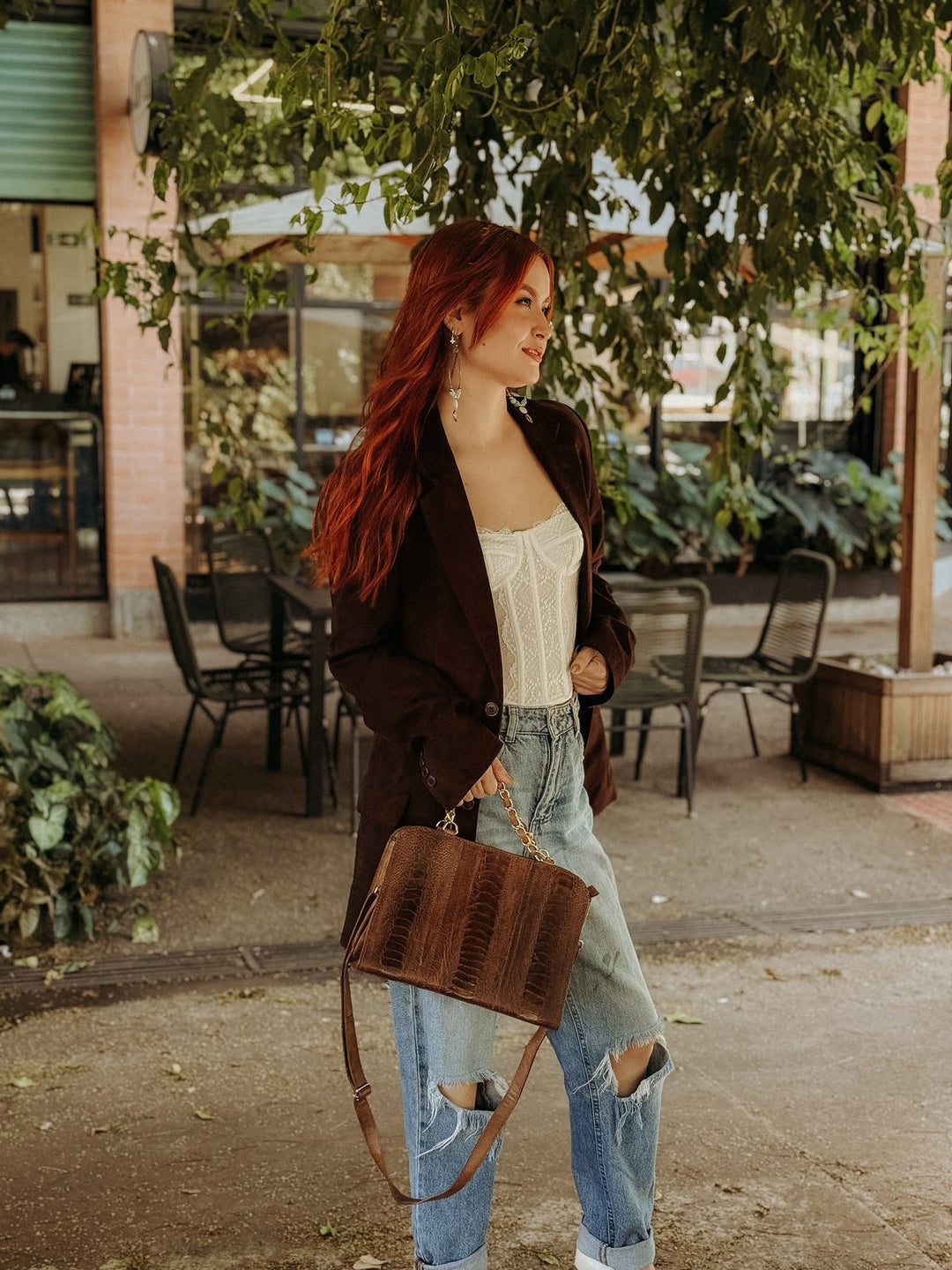 Bolsa social transversal Strut em canela de avestruz mostrando o tamanho real no corpo