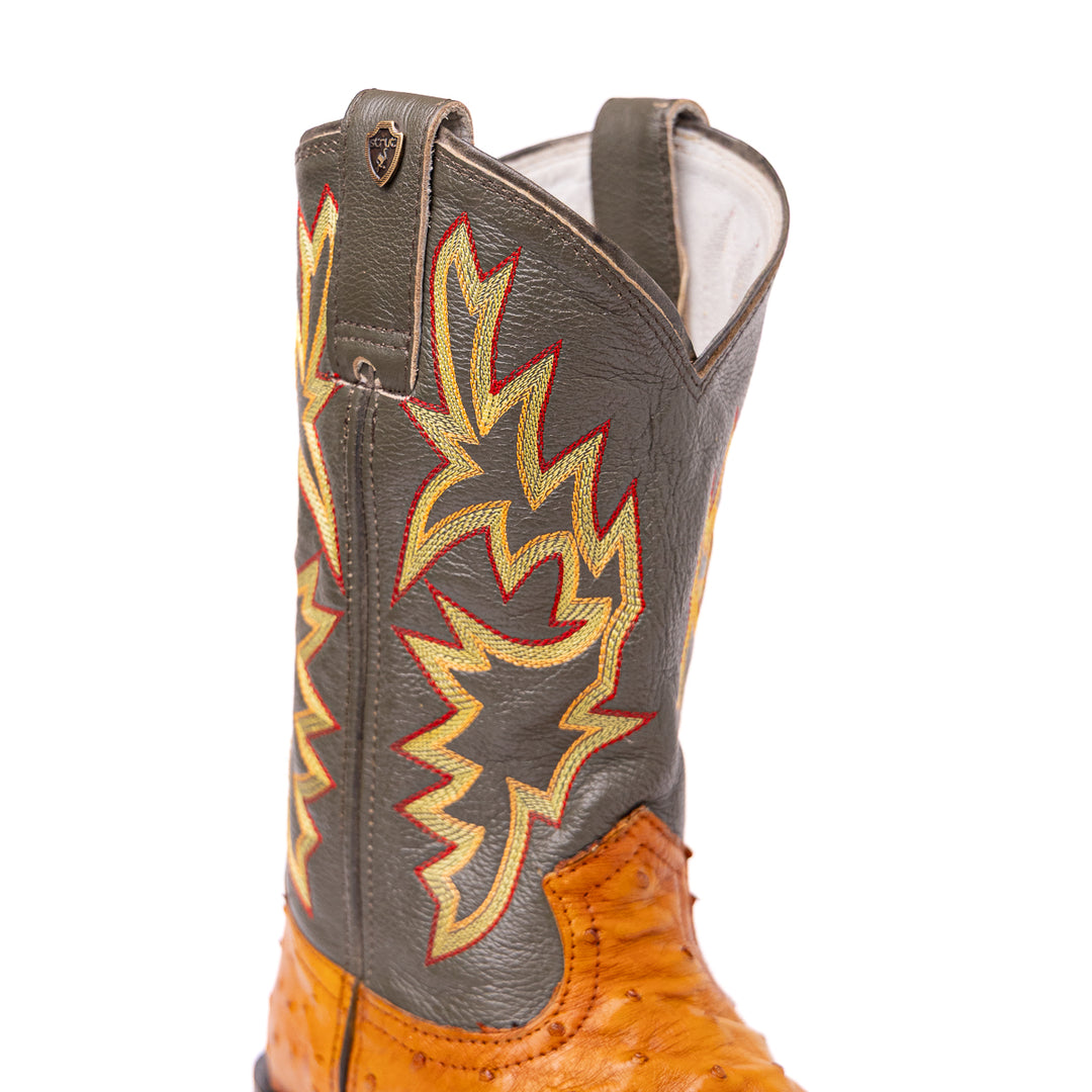 Detalhe do cano da bota masculina strut em couro de avestruz cheio chestnut com cano verde-oliva bordado