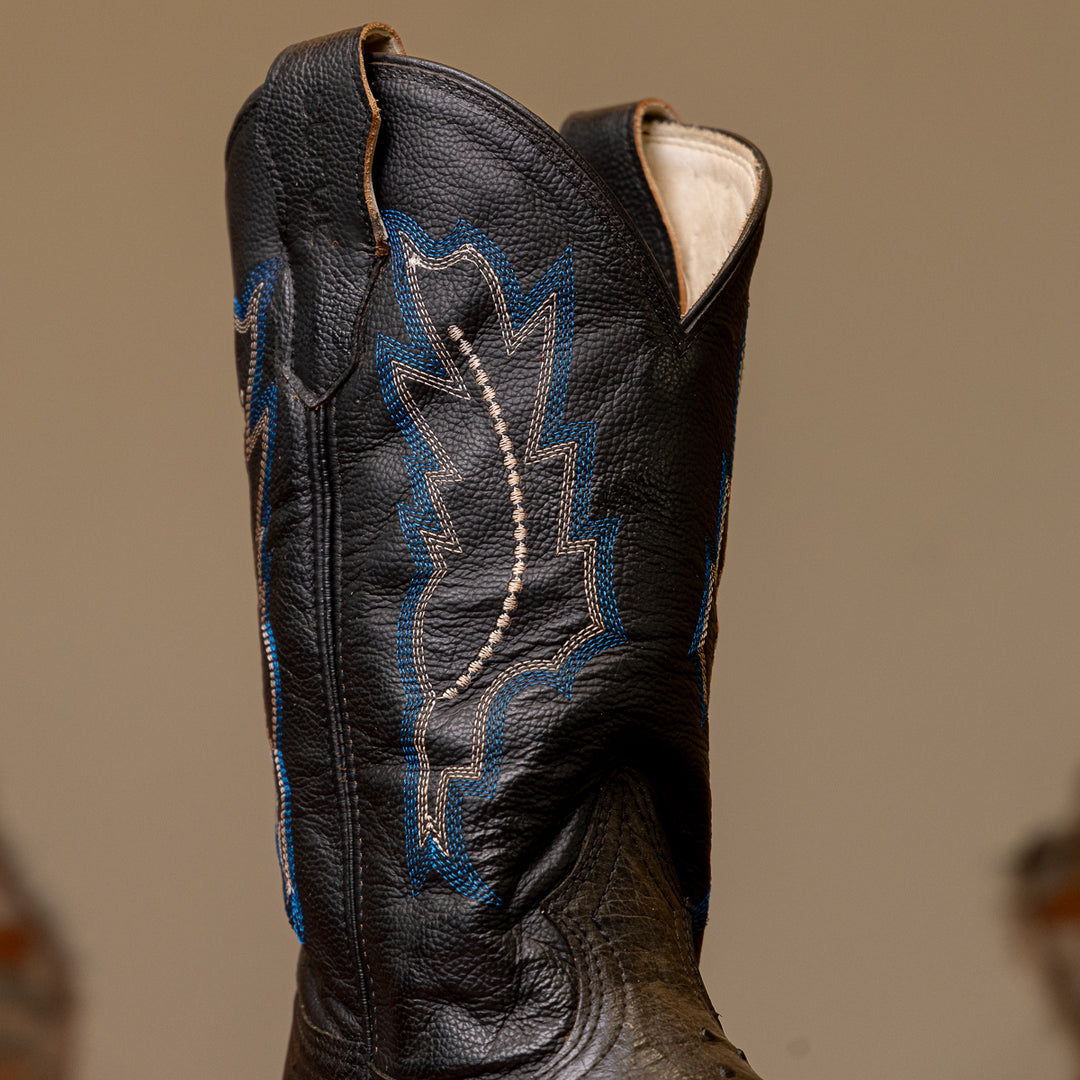Detalhe do cano da bota masculina strut em couro de avestruz cheio preto com cano preto bordado azul