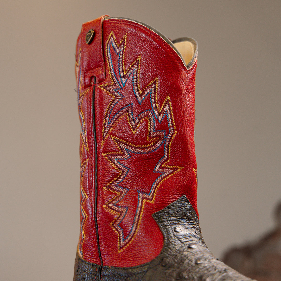 Detalhe do cano da bota masculina strut em couro de avestruz cheio preto com cano vermelho bordado azul e amarelo